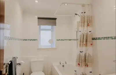 a bathroom with a toilet and a shower curtain at Glasgow - 1 Bedroom Apartment in Glasgow