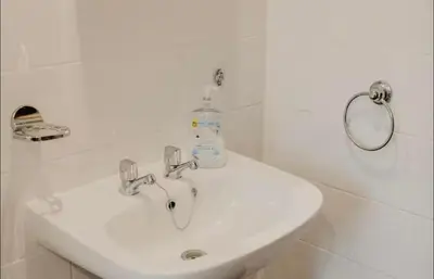 a bathroom sink with a bottle of soap on it at Glasgow - 1 Bedroom Apartment in Glasgow