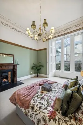 a bedroom with a large bed and a fireplace at Grand 2 Bed West End Residence in Glasgow