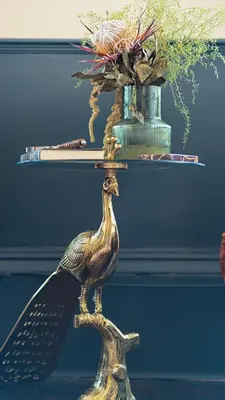 a bird standing on a stand with a vase at Grand 2 Bed West End Residence in Glasgow