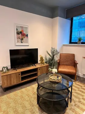 a living room with a flat screen tv and a coffee table at Stylish 2 bed City Retreat in Glasgow