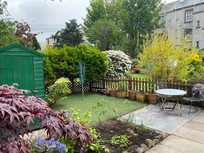 a garden with a table and a fence at Garden flat in Largs