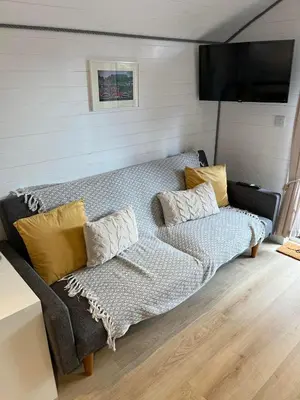 a living room with a couch and a television at Pod at Lonan drive in Oban