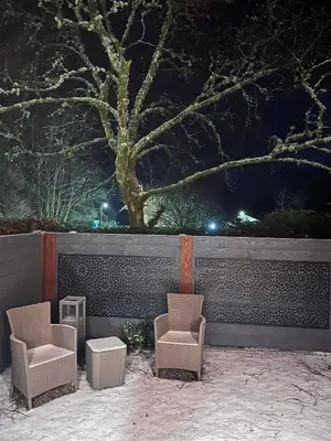 two chairs and a table in front of a wall at Pod at Lonan drive in Oban