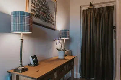 a room with a table with two lamps and a window at Scottish Apartment with Amazing Castle Views in Edinburgh