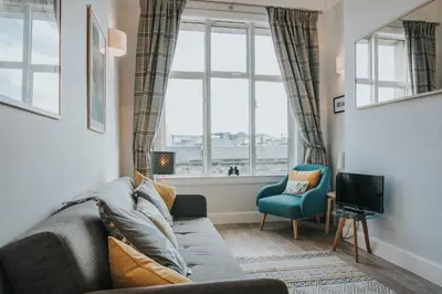 a living room with a couch and a window at Scottish Apartment with Amazing Castle Views in Edinburgh