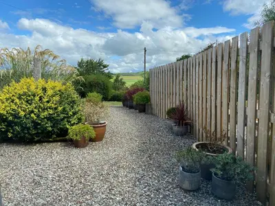 a garden with potted plants and a fence at Thornhill cottage with views of the Trossachs in Thornhill