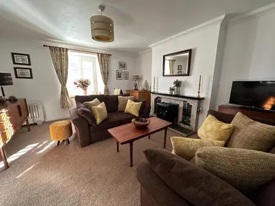 a living room with a couch and a fireplace at Thornhill cottage with views of the Trossachs in Thornhill