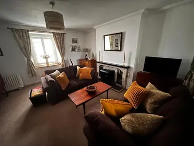 a living room with a couch and a fireplace at Thornhill cottage with views of the Trossachs in Thornhill