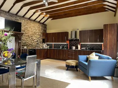 a living room with a blue couch and a table at WestLaigh Central Scotland with outdoor BBQ Hut, pets welcome in Strathaven