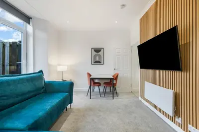 a living room with a blue couch and a table at George St Getaway in Ayr