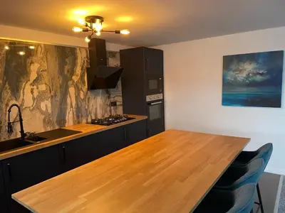 a kitchen with a wooden counter top and a sink at Harbour bliss in Ardrossan