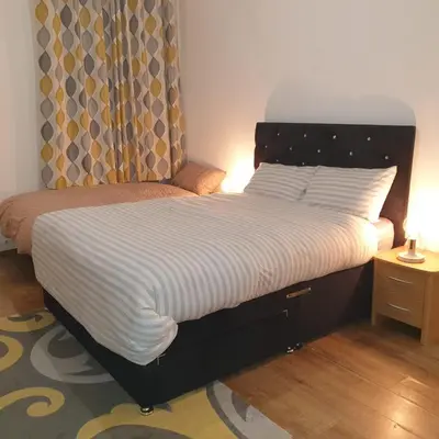 a bedroom with a large bed with a large headboard at Newly Furnished Flat 4 Minutes Walk To Metro in Glasgow