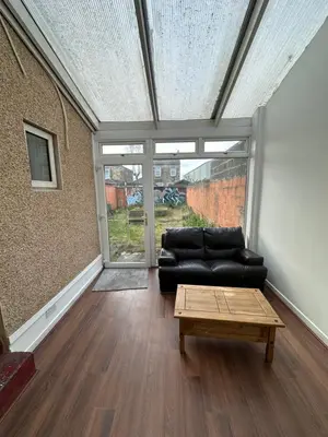 a living room with a black couch and a coffee table at Spacious 5 Bedroom House Close to Central West End in Glasgow