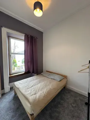 a bedroom with a bed and a window at Spacious 5 Bedroom House Close to Central West End in Glasgow