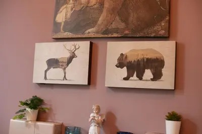 two pictures of a bear and a deer on a wall at Charming 2 Bed Apartment in the heart of the West End in Glasgow