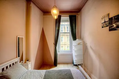 a bedroom with a bed and a window at Charming 2 Bed Apartment in the heart of the West End in Glasgow