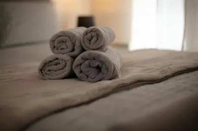 a pile of towels sitting on top of a bed at Charming 2 Bed Apartment in the heart of the West End in Glasgow
