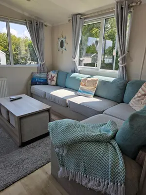 a living room with a couch and a table at Barbara's Caravan Craig Tara in Ayr