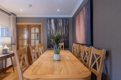 a dining room with a wooden table and chairs at Luss Cottages at Glenview in Luss
