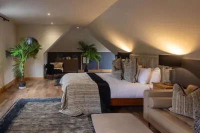 a bedroom with a large bed and a couch at Luss Cottages at Glenview in Luss