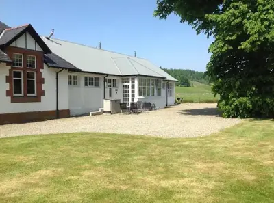 a white building with a large yard in front of it at Wagtail Cottage in Kilmartin