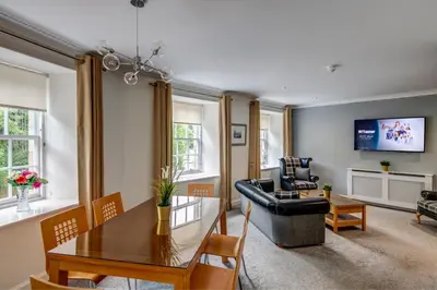 a living room with a dining room table and a couch at New Lanark Self Catering Waterhouses in Lanark