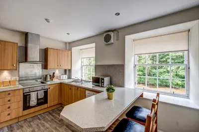 a kitchen with a table and a large window at New Lanark Self Catering Waterhouses in Lanark