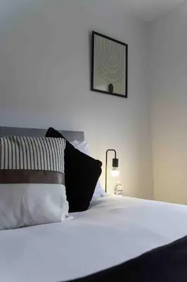 a bedroom with a white bed with a picture on the wall at 2 BDR House By Caledonia Luxe Stays Short Lets & Serviced Accommodation Glasgow in Glasgow
