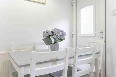 a white dining room table and chairs with a vase of flowers at 2 BDR House By Caledonia Luxe Stays Short Lets & Serviced Accommodation Glasgow in Glasgow