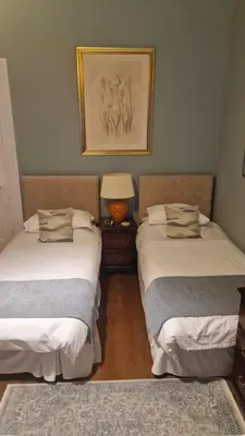a room with two beds and a lamp in it at Maybank Guest House in Helensburgh