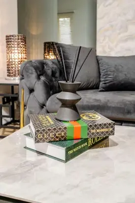 a coffee table with two books and a vase on it at The Pad in Paisley