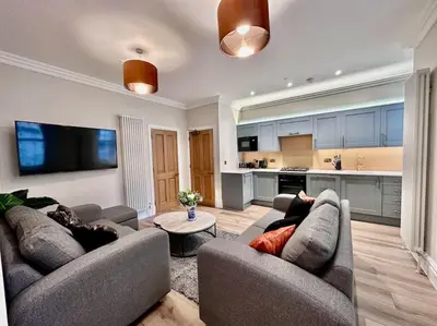 a living room with two couches and a kitchen at Spectacular 2 bed, 2 bath in Edinburgh City Centre in Edinburgh