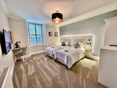 a bedroom with two beds and a desk and a window at Spectacular 2 bed, 2 bath in Edinburgh City Centre in Edinburgh