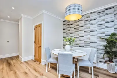 a dining room with a white table and chairs at Spectacular 2 bed, 2 bath in Edinburgh City Centre in Edinburgh