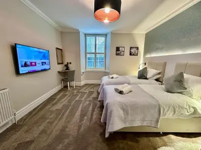 a bedroom with two beds and a flat screen tv at Spectacular 2 bed, 2 bath in Edinburgh City Centre in Edinburgh