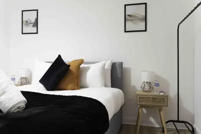 a bedroom with a bed with black and white pillows at Montgomery Avenue in Paisley