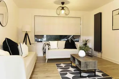 a living room with a white couch and a window at Montgomery Avenue in Paisley