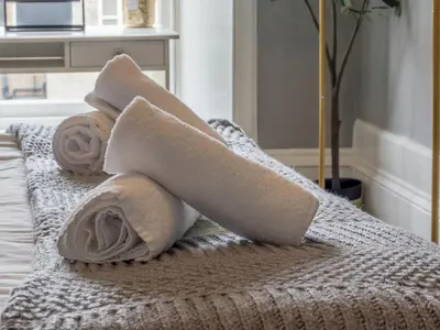 a pile of towels sitting on top of a bed at Wonderful West End - Pass the Keys in Glasgow