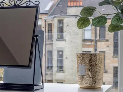 a computer monitor sitting on a table next to a plant at Wonderful West End - Pass the Keys in Glasgow
