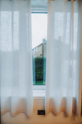 a window with white curtains in a room at Large bedroom, close to Airport and City Centre in Edinburgh