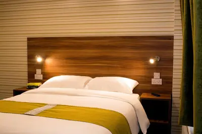 a bedroom with a large bed with a wooden headboard at Helix Hotel in Grangemouth