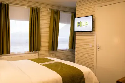 a bedroom with a bed and a flat screen tv at Helix Hotel in Grangemouth