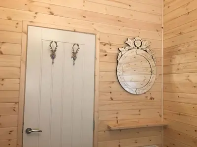 a bathroom with a door and a mirror at Teaghlach Luxury Lodge with hot tub Balquhidder Mhor Lodges in Lochearnhead