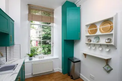 a kitchen with green cabinets and a window at Lovely spacious 2 Bed Flat in Glasgow