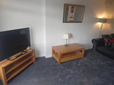 a living room with a flat screen tv and a couch at 3 bedroom terraced house in Larkhall