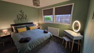 a bedroom with a bed and a sink and a mirror at 175 On Clyde - Spacious & Cosy Cedar Wood Bungalow in Helensburgh