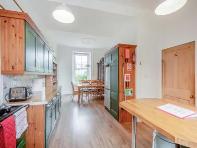 a kitchen with green cabinets and a dining room at Springvale in Cardross