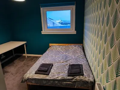 a bed in a room with a window at Modern 2-in-1 Retreat for Groups in Port Glasgow