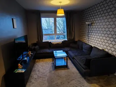 a living room with a couch and a table at Modern 2-in-1 Retreat for Groups in Port Glasgow